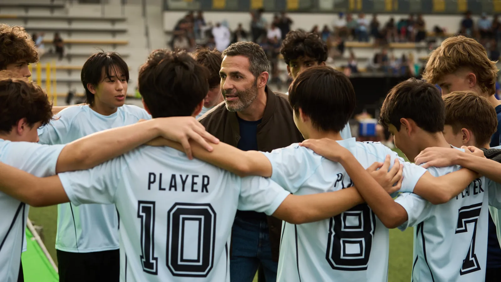 Young football players in a team huddle with their coach