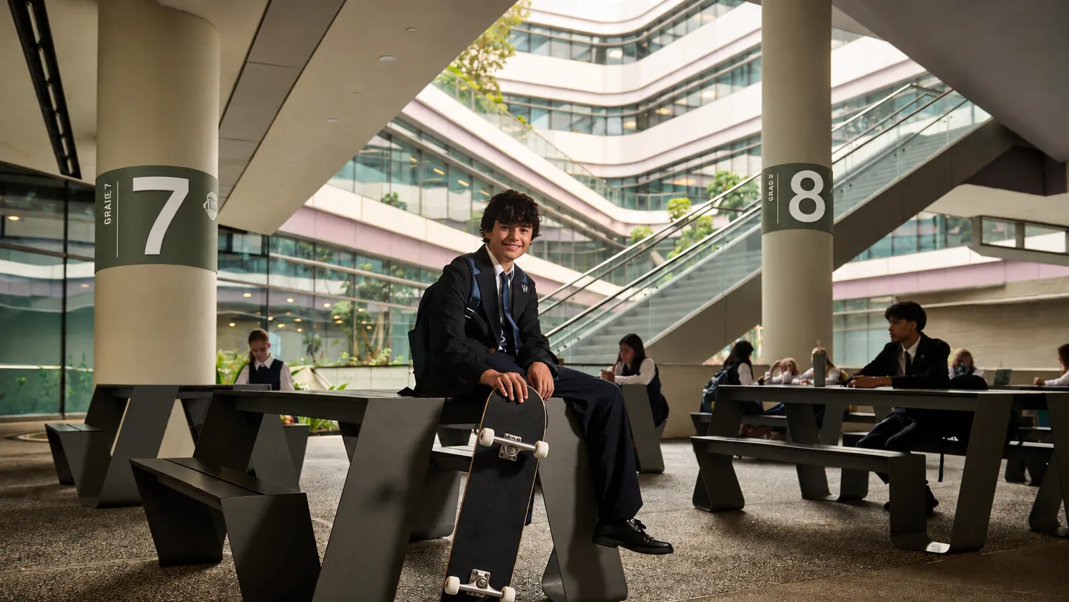 Students in uniform in a bright, multi-level school atrium